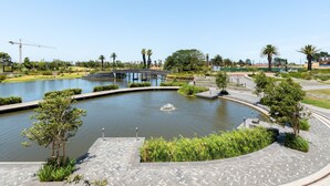 A landscaped area with a water feature, pathways, and greenery.
