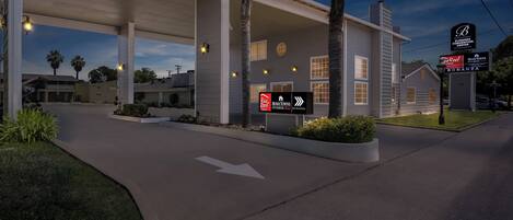 A gas station with a Red Roof Inn sign, a Bonanza Convention Center sign, and a Hometown Studios sign.