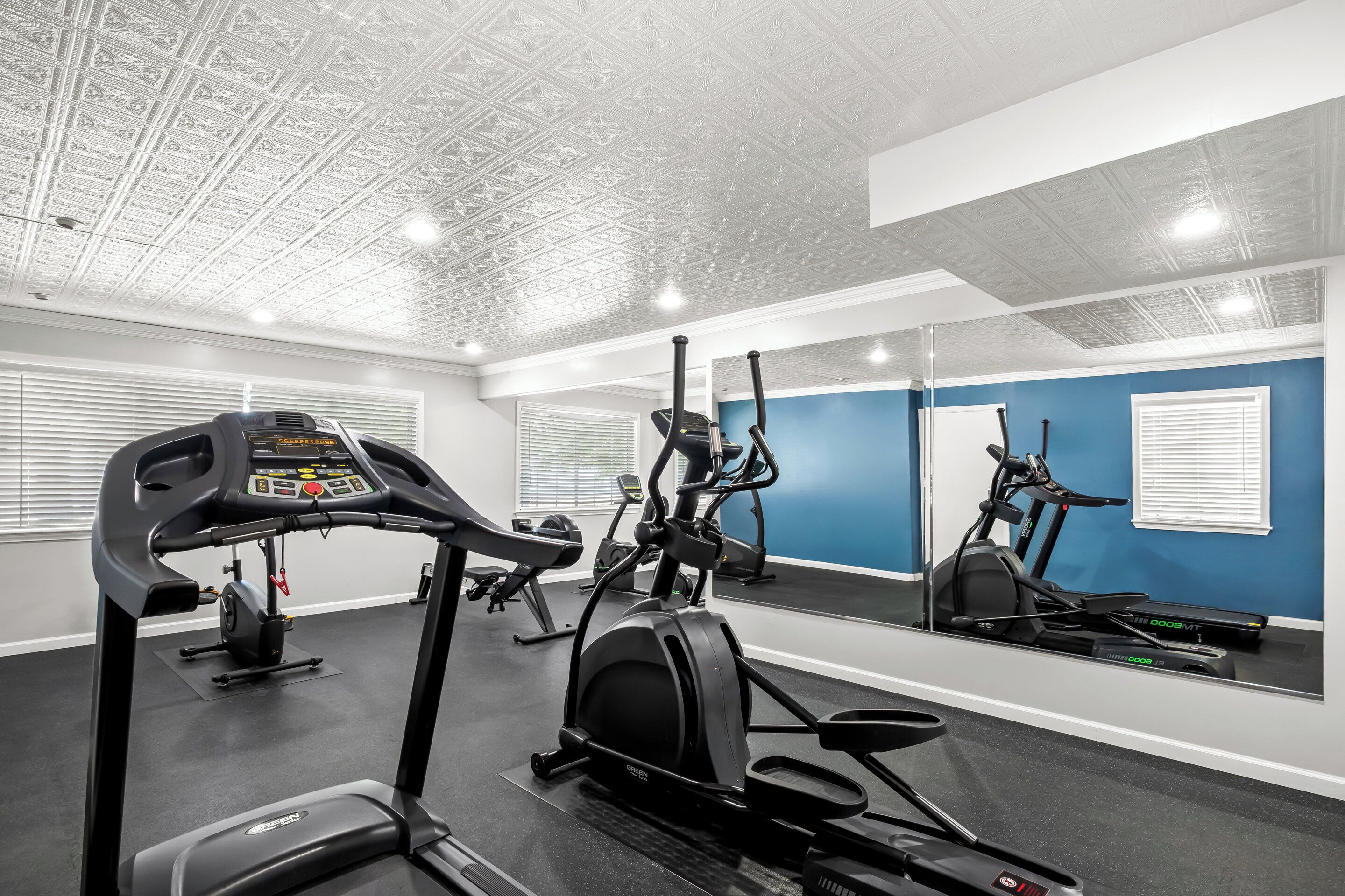 A gym with treadmills, an elliptical, and a stationary bike.