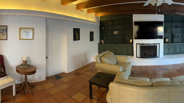 A cozy living room with a fireplace, a sofa, and a coffee table. - Refined Home w/Game Room & Large Lounge (Westworth Village)