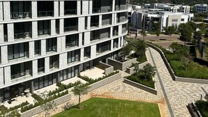 Ein mehrgeschossiges Gebäude mit modernem Architekturstil, mit Balkonen und großen Fenstern.