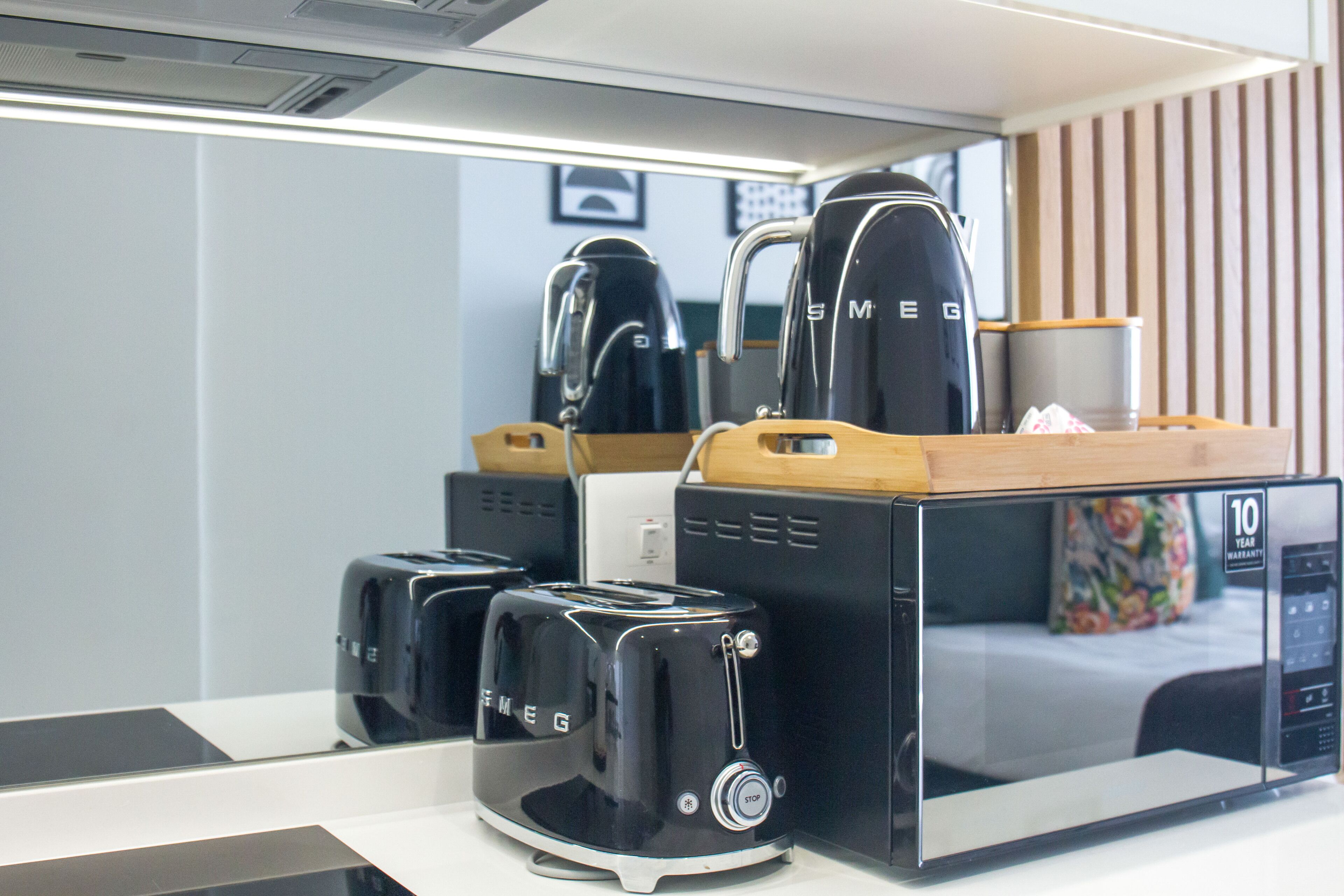 A kitchen area with a coffee maker, toaster, and microwave.
