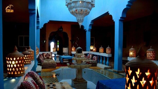 A luxurious interior with a central fountain, blue walls, and ornate lanterns.