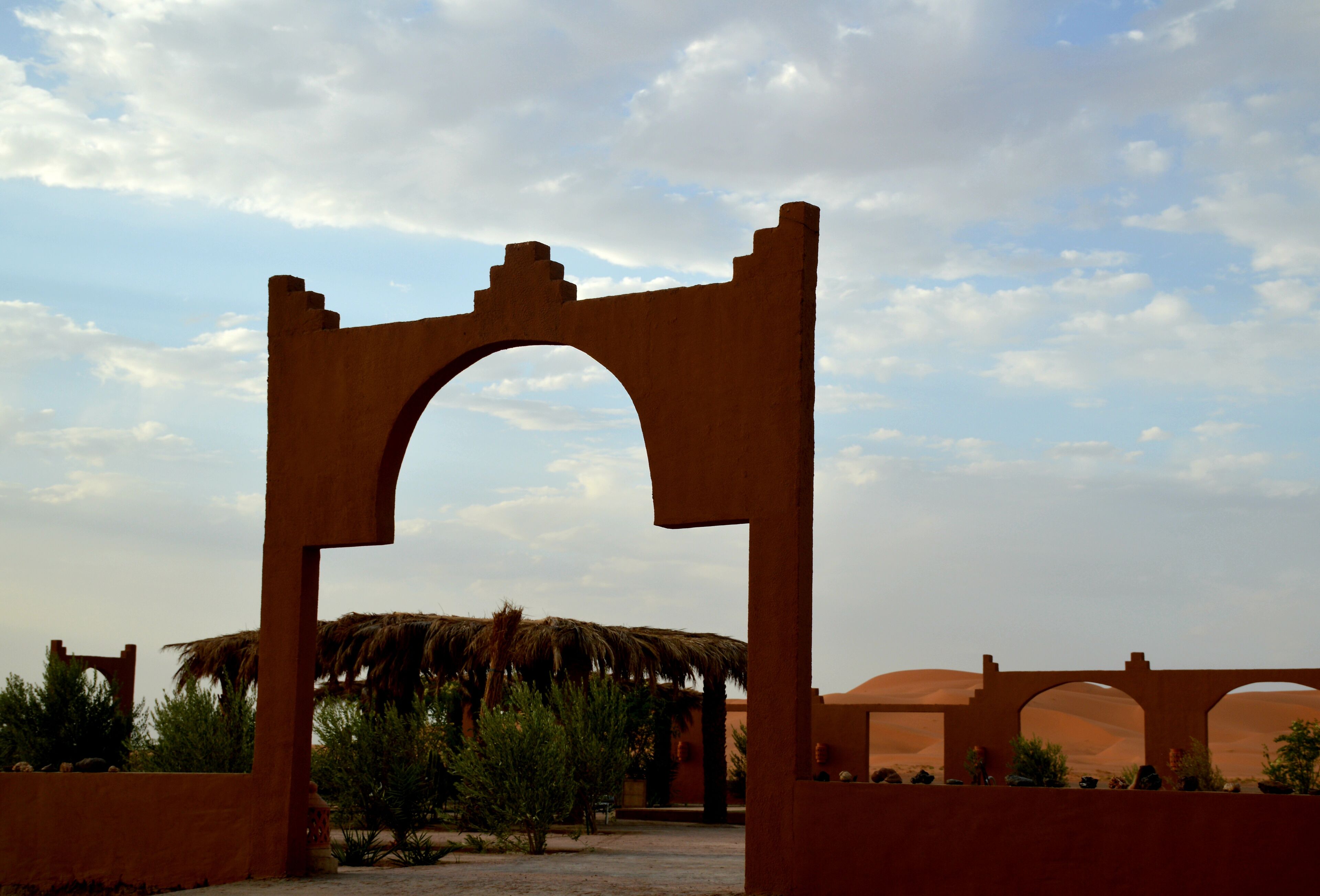 Paisaje desértico con una gran estructura en forma de arco.