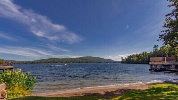 A lakeside view with a dock, a boat, and a building on the right. - 2 Bed /2 bath cabin w/ Lake George access (Lake George)