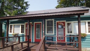 A small building with a porch, a red door, and a window with a hanging flower pot. - 2 Bed /2 bath cabin w/ Lake George access (Lake George)