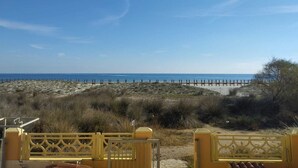 Une vue sur la plage, avec une clôture en bois et un ciel dégagé.