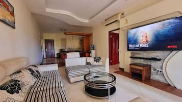 Apartamento executivo | Área de estar | Smart TV 24 polegadas com canais via satélite