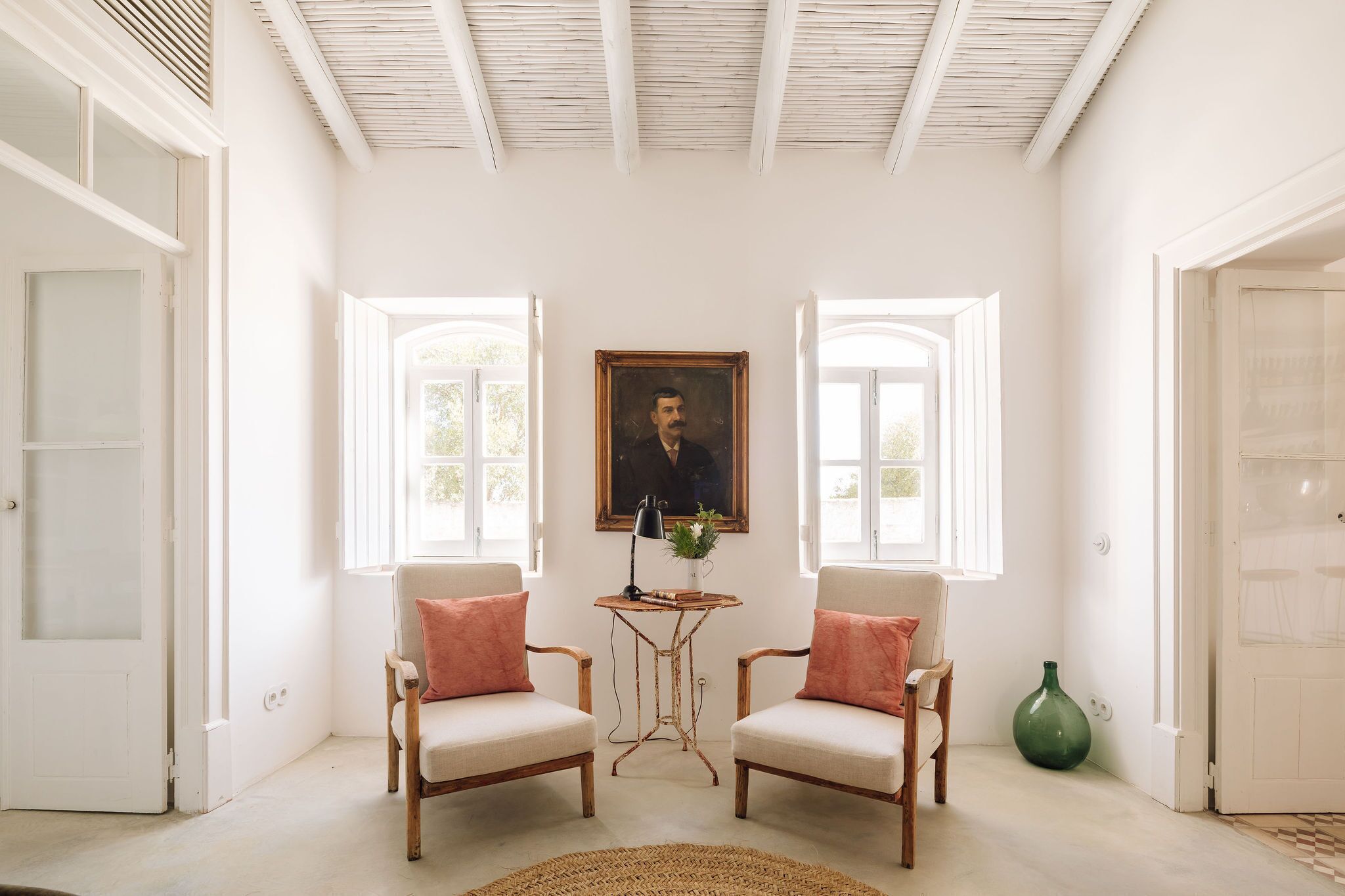Una habitación con dos sillas, una mesa y un cuadro en la pared.