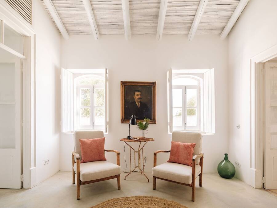 Una habitación con dos sillas, una mesa y un cuadro en la pared.
