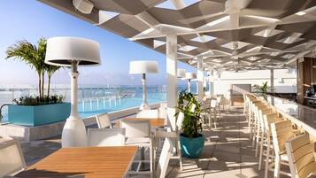 Relax by the pool with a view, surrounded by lush greenery and comfortable seating.