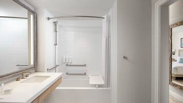 A modern bathroom with a shower, a bathtub, and a vanity with a mirror.