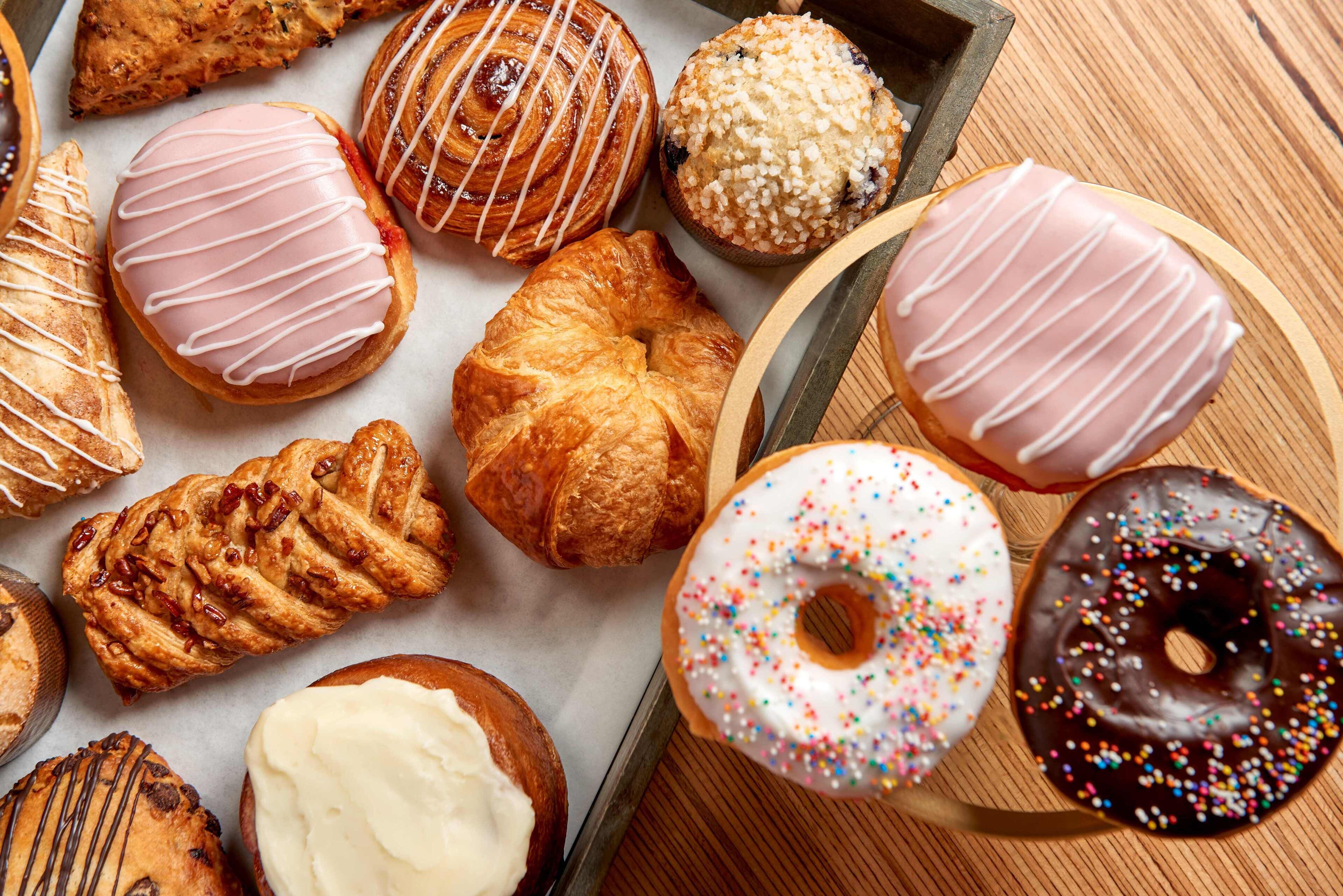 Variedad de productos de pastelería, incluyendo croissants, danesas y rosquillas con distintos rellenos.