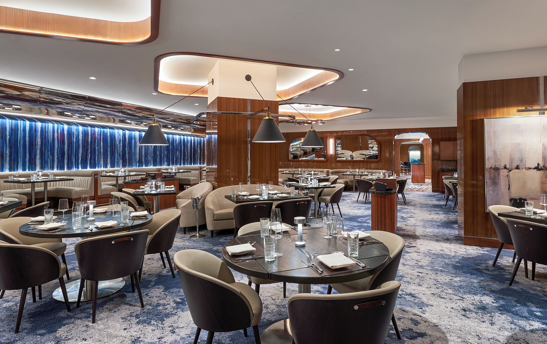 A modern dining area with round tables, chairs, and ambient lighting.
