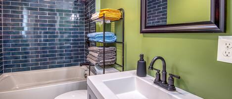 Une salle de bain avec une baignoire, des toilettes et un lavabo avec un miroir au-dessus.