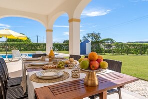 Enjoy a meal al fresco with a view of the pool and lush surroundings.