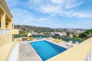 Une piscine sur le toit offrant une vue dégagée sur une ville en arrière-plan.