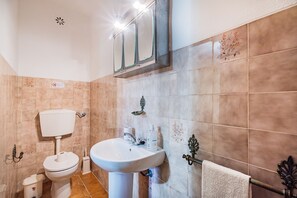 Une salle de bain avec des toilettes, un lavabo et un miroir.