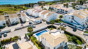 Zona residencial costera con edificios blancos, una piscina y vista al mar.