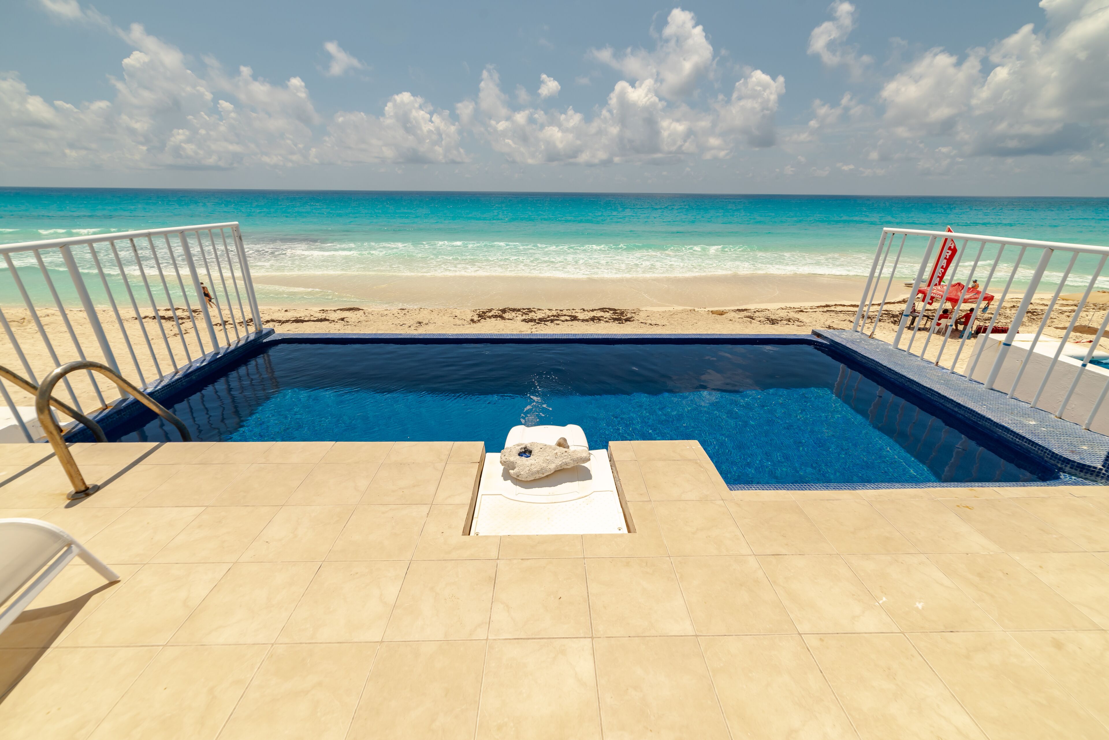 Una piscina con vista a la playa y al océano.