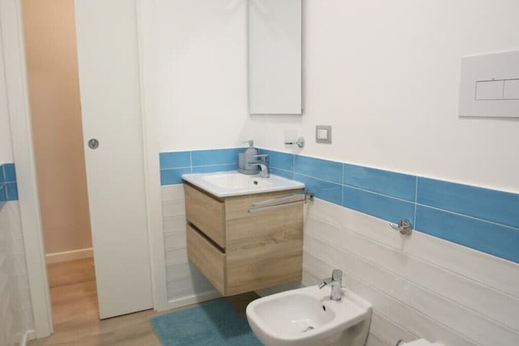 Un baño con un lavamanos blanco, un espejo y un bidé.