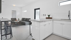 A modern kitchen with white cabinetry, a marble countertop, and a built-in sink. - Modern Villa 1 in Miami close to Brickell, Wynwood, near everything (Miami)
