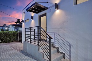 Un edificio moderno con una escalera, una puerta y una antena parabólica.