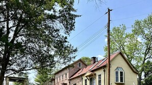 A row of stone and wooden houses with a well-maintained lawn in front.