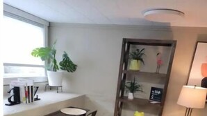 Un espace de vie compact comprenant un coin repas, un petit coin salon et une bibliothèque.
