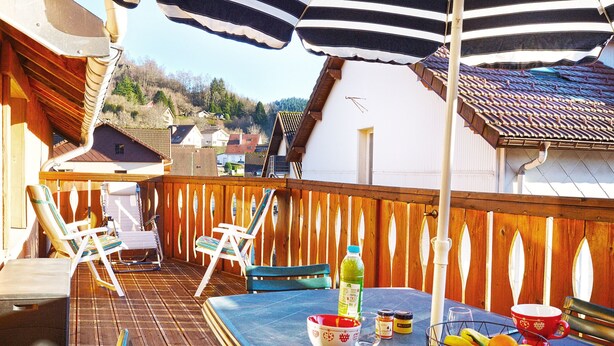 A wooden deck with a table, chairs, and umbrellas. - Comme Chez Soi - Vue montagne et garage privé (La Bresse)
