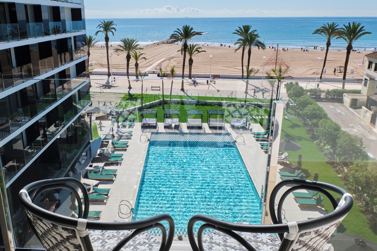 Vista a la piscina con una vista despejada de la playa y el océano.
