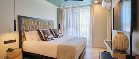 A modern bedroom with a large bed, a ceiling fan, a bedside table, and a large window with curtains.