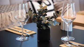 Una mesa de comedor con dos copas de vino y una pequeña planta en maceta.