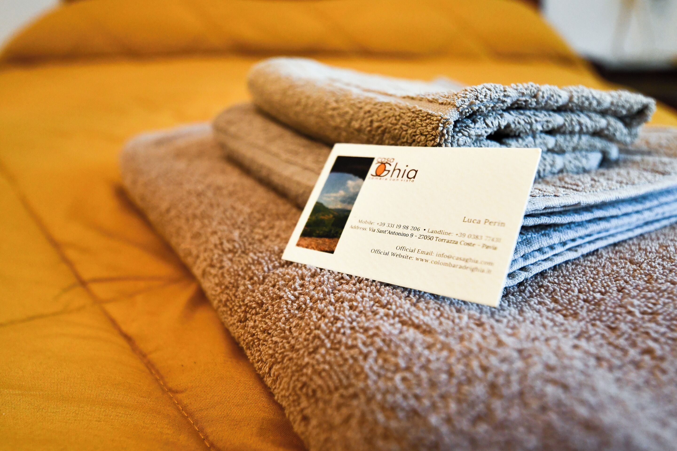 A folded towel with a business card on top.