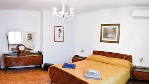 A bedroom with a bed, dresser, mirror, and two framed pictures on the wall.