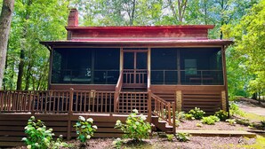 Eine Holzhütte mit Veranda und einer Treppe zum Eingang.