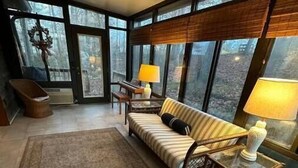 Ein großzügiger Wohnbereich mit einem großen Fenster, einem Sofa, einem Couchtisch und einem Teppich.