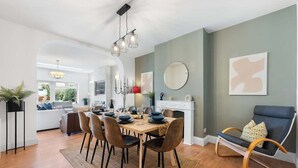 A dining area with a wooden table, chairs, and a chandelier. - Cosy 5BRLuxe House, w/Games Room, Great for Groups (Widley)