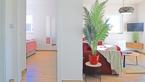 Una sala moderna con un sofá rojo, una mesa de centro y una planta en maceta.
