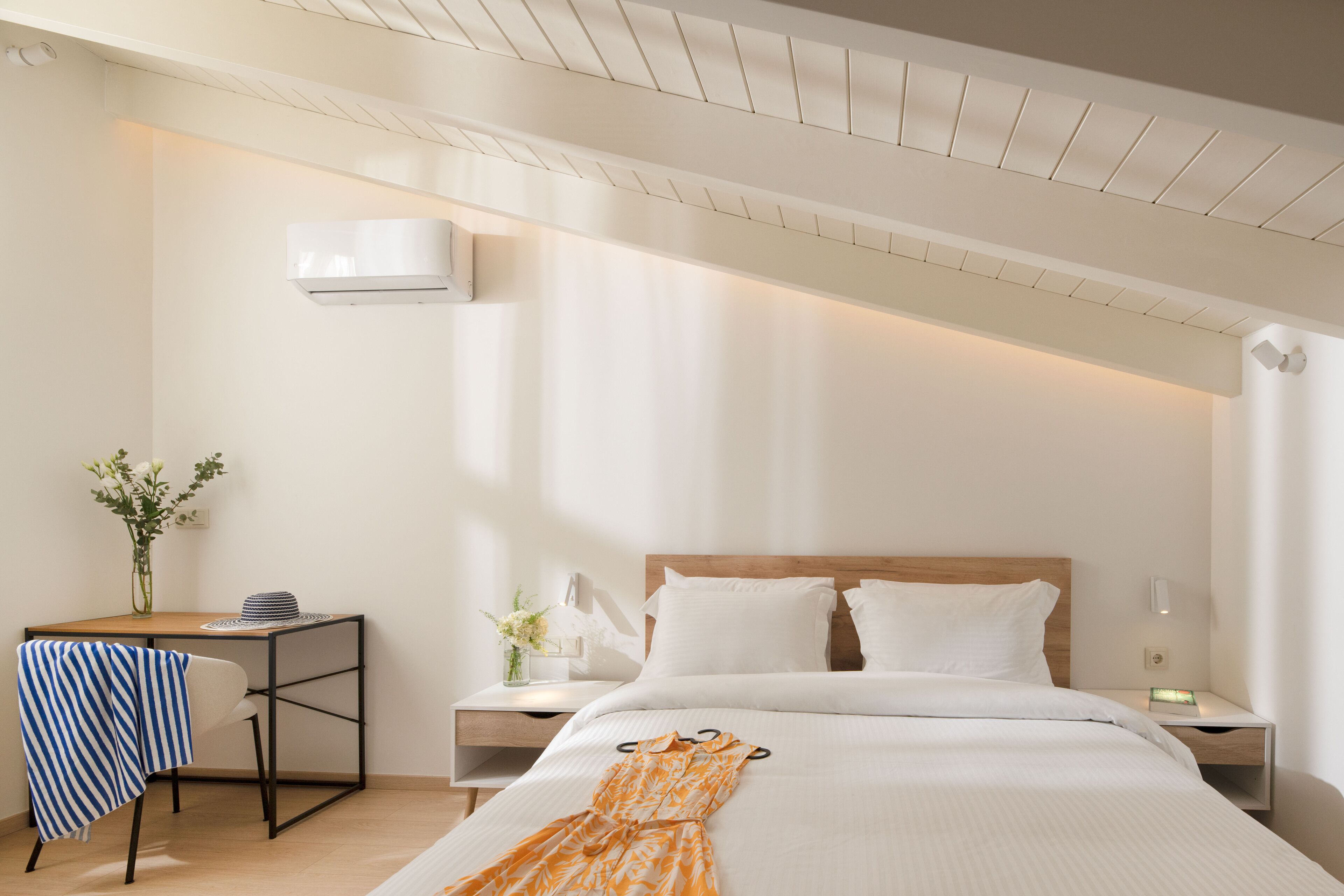 A hotel room with a bed, bedside tables, a desk, and a chair.