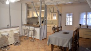 Eine Küche mit Essbereich, inklusive Tisch und Stühlen, einer Bar und einer Waschmaschine.
