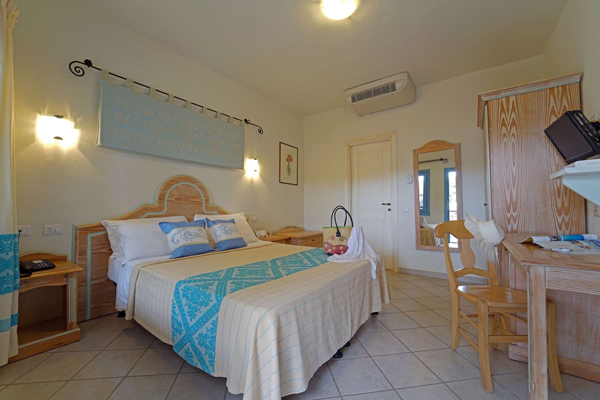 Une chambre à coucher avec un lit, des tables de chevet, un bureau et une chaise.
