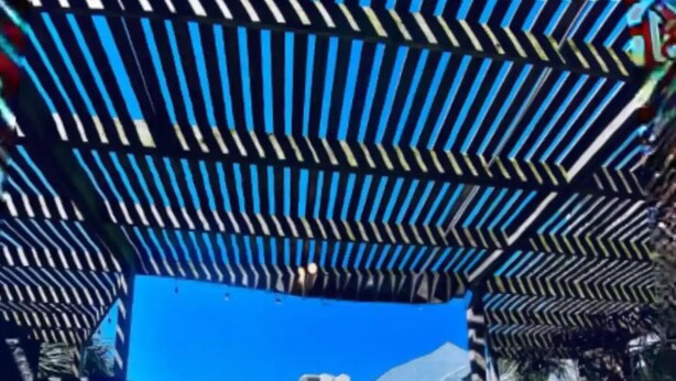 Ein Schwimmbecken mit blauem Himmel und einem Gebäude im Hintergrund.