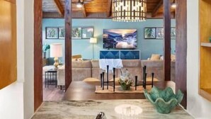A modern interior with a marble countertop, a sink, and a dining area with a table and chairs. - Mid-mod, boho home w/ a pool! (St. Augustine)
