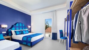 A hotel room with a large bed, two bedside tables, a chair, and a wardrobe.