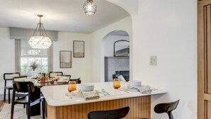 Una cocina moderna con una isla central, taburetes de bar e iluminación colgante.