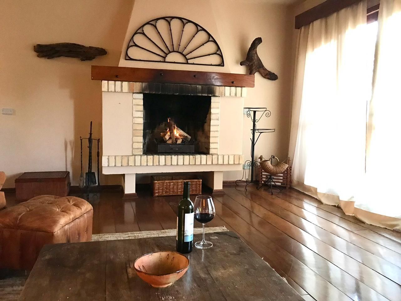 Una sala de estar acogedora con chimenea, piso de madera y diseño rústico.