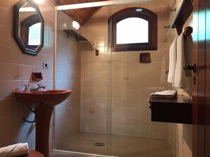 A bathroom with a pedestal sink, a shower enclosure, and a towel rack. - Country Home (Campos do Jordão)