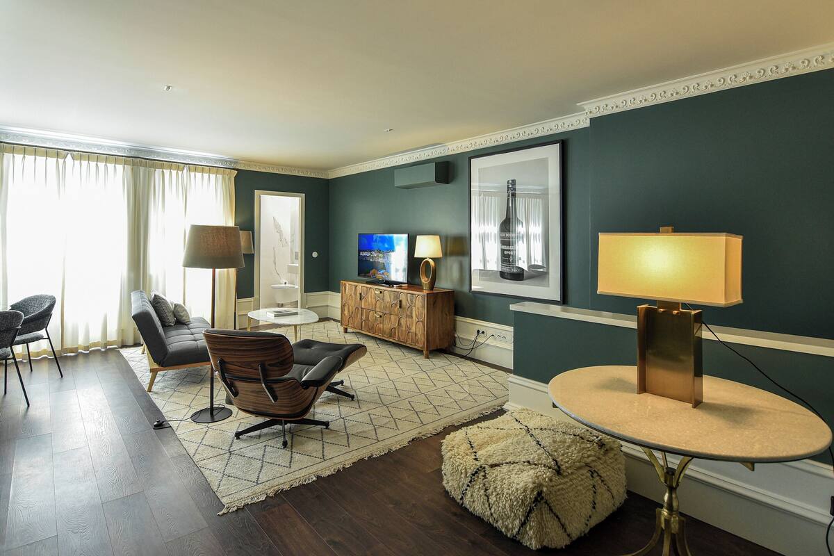 Una sala de estar moderna con sofá, sillas, una mesa de centro y televisor.