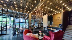 A modern interior with a bar area, seating, and a visible logo on the wall. - The Willow Phangan (Ko Pha-ngan)